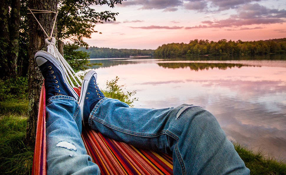 Man in hammock relaxing at a lake